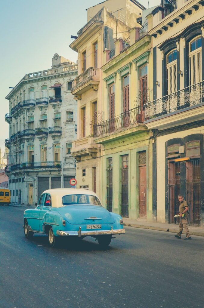 stary niebieski samochód z białym dachem na ulicach Kuby